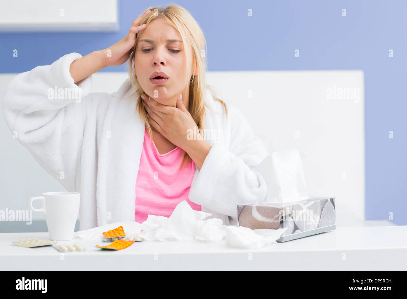Junge Frau Husten während leiden unter Kopfschmerzen und Kälte in Küche Stockfoto