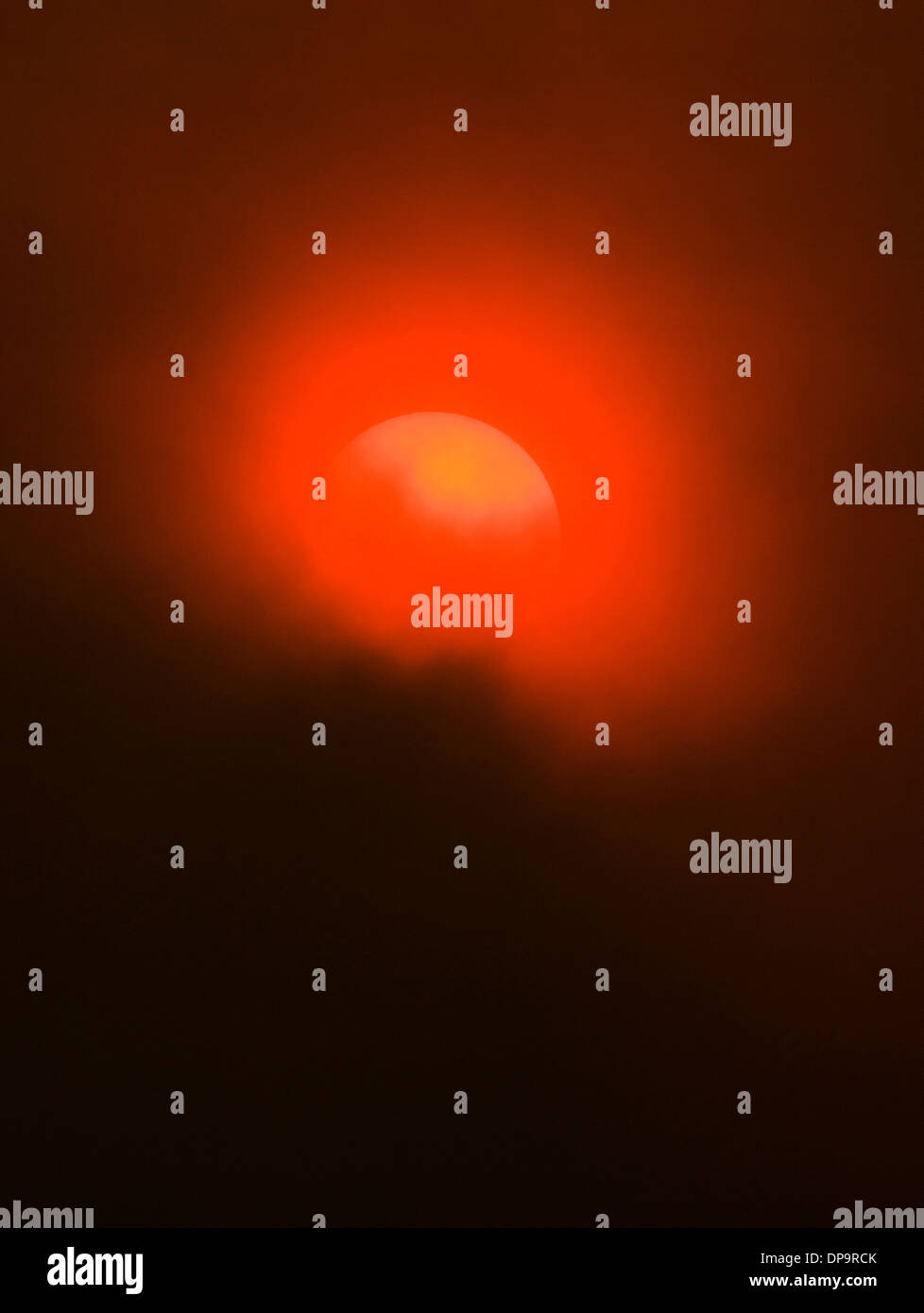 Rauch von Waldbränden schafft ein ungewöhnliche unheimliches orange leuchten, die untergehende Sonne. Stockfoto