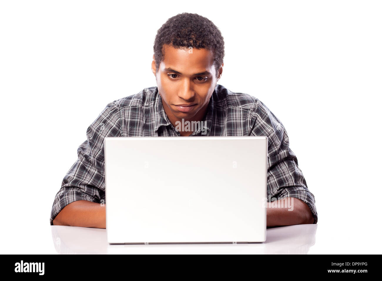 Dunkelhaeutigen jungen Mann konzentriert an seinem Laptop suchen Stockfoto