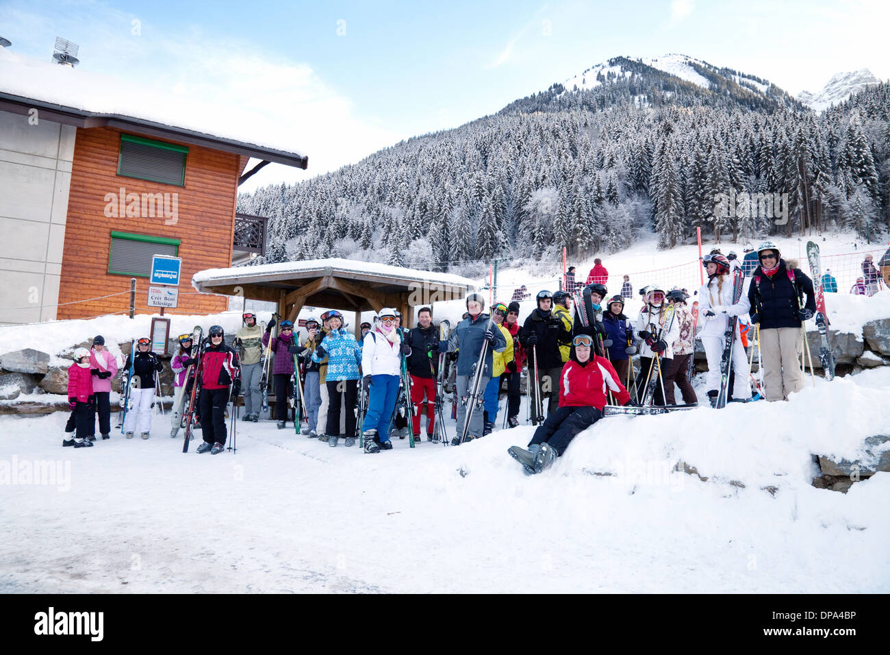 Skifahrer warten an einer Bushaltestelle für den Skibus, La Chapelle D'Abondance, Französische Alpen, Hautes Savoie, Les Portes du Soleil, Frankreich Stockfoto