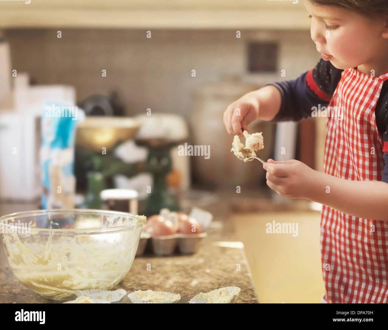 Kind-Holding-Löffel mit Kuchen-mix Stockfoto