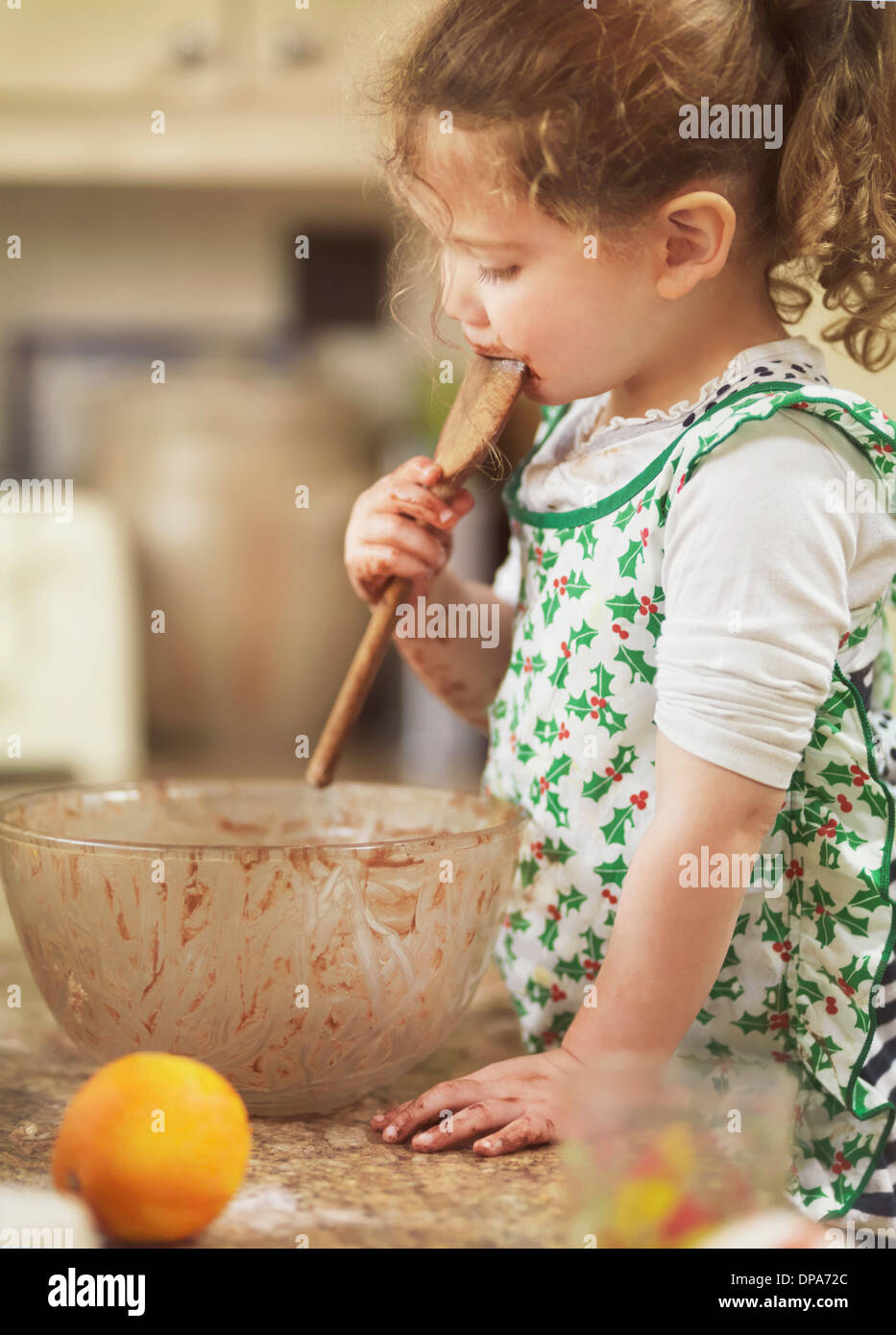 Schmeckenden Kuchen Kind vermischen mit Holzlöffel Stockfoto