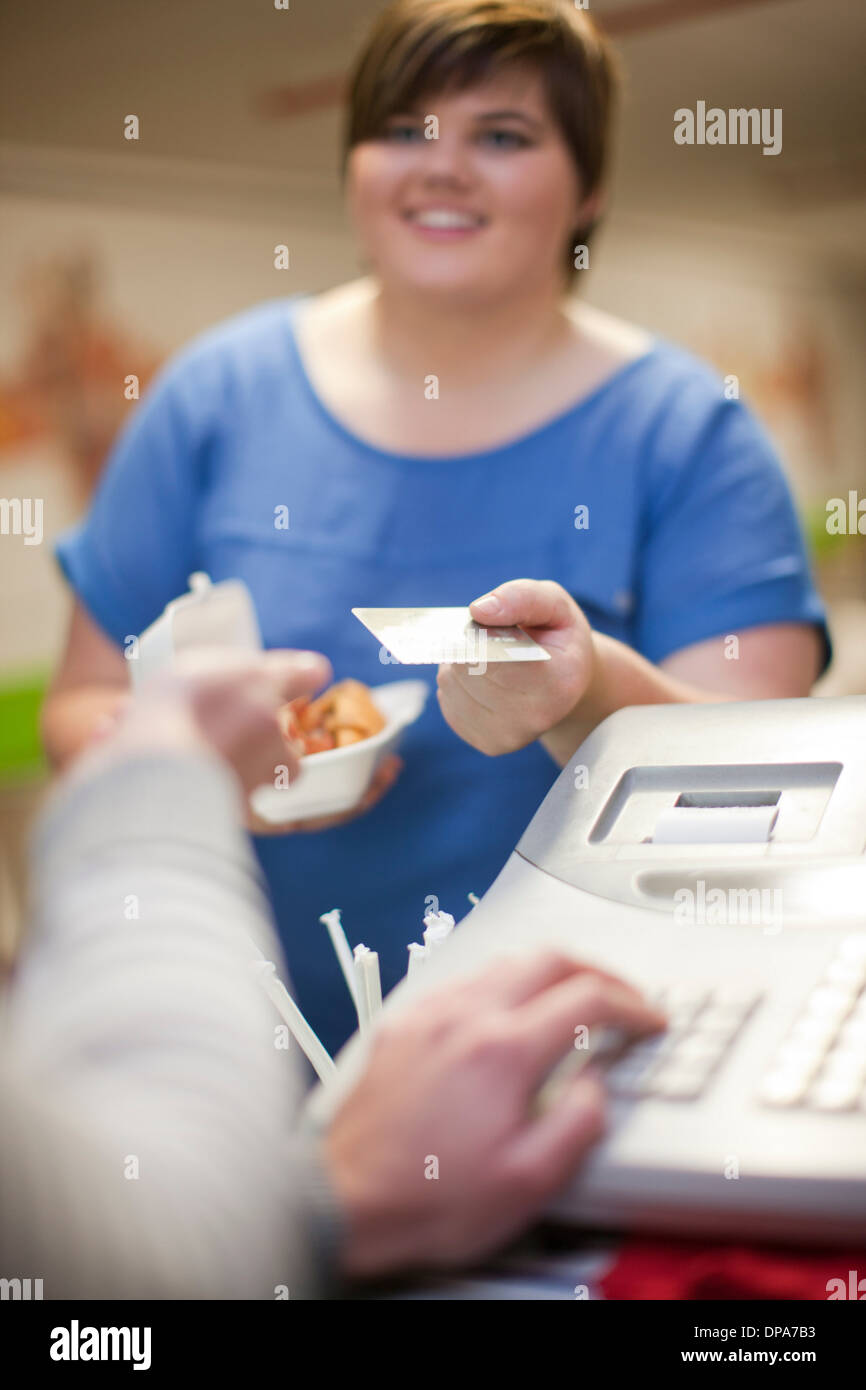 Junge Frau, die Zahlung für Take-away Bestellung im café Stockfoto