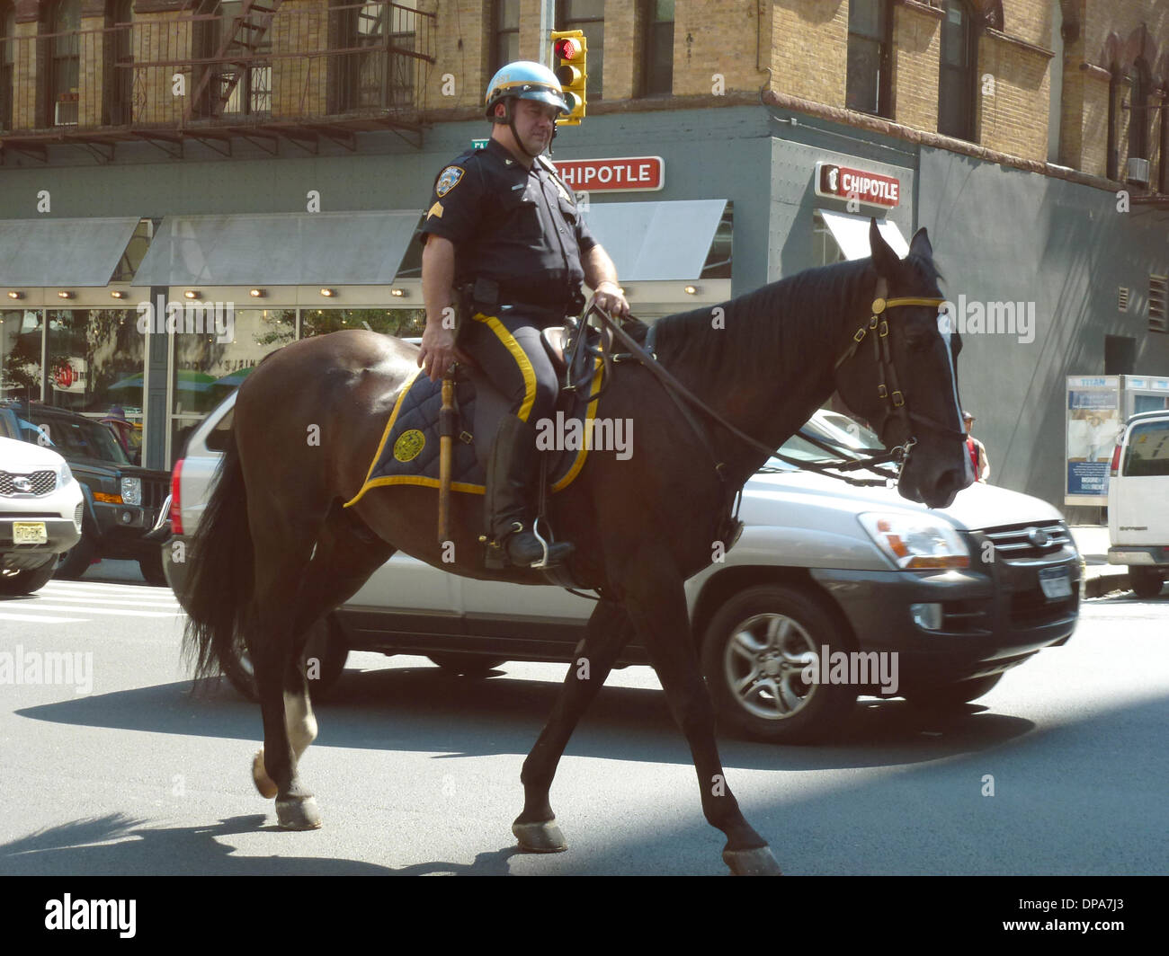 Chelsea, New York City, USA. 17. August 2013. Ein berittener Polizisten überquert die Kreuzung der Seventh Avenue und 26th Street in Chelsea, New York City, Vereinigte Staaten von Amerika, 17. August 2013. Foto: Alexandra Schuler/Dpa - kein Draht-SERVICE-/ Dpa/Alamy Live News Stockfoto