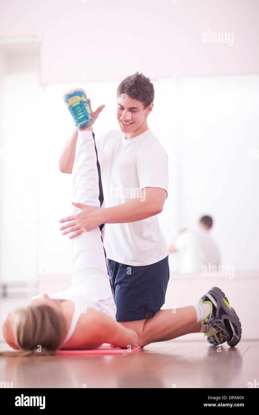 Junger Mann Training mit Kunden in Fitness-Studio Stockfoto