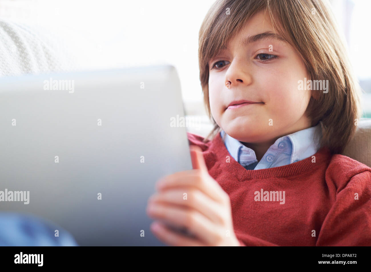 Junge auf Sofa mit digital-Tablette Stockfoto