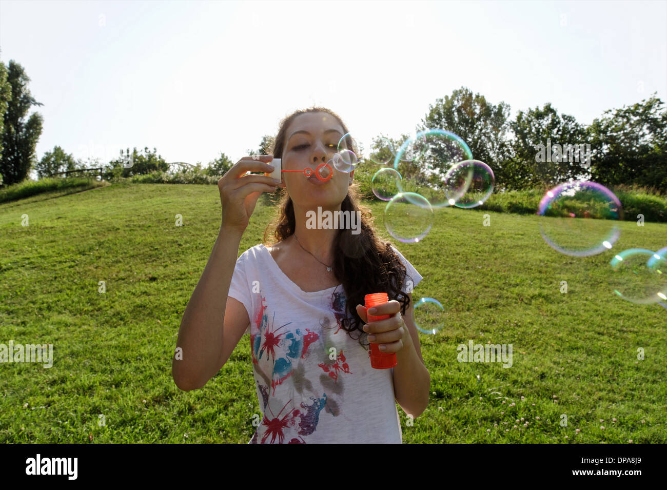 Junge Frau bläst Seifenblasen Stockfoto