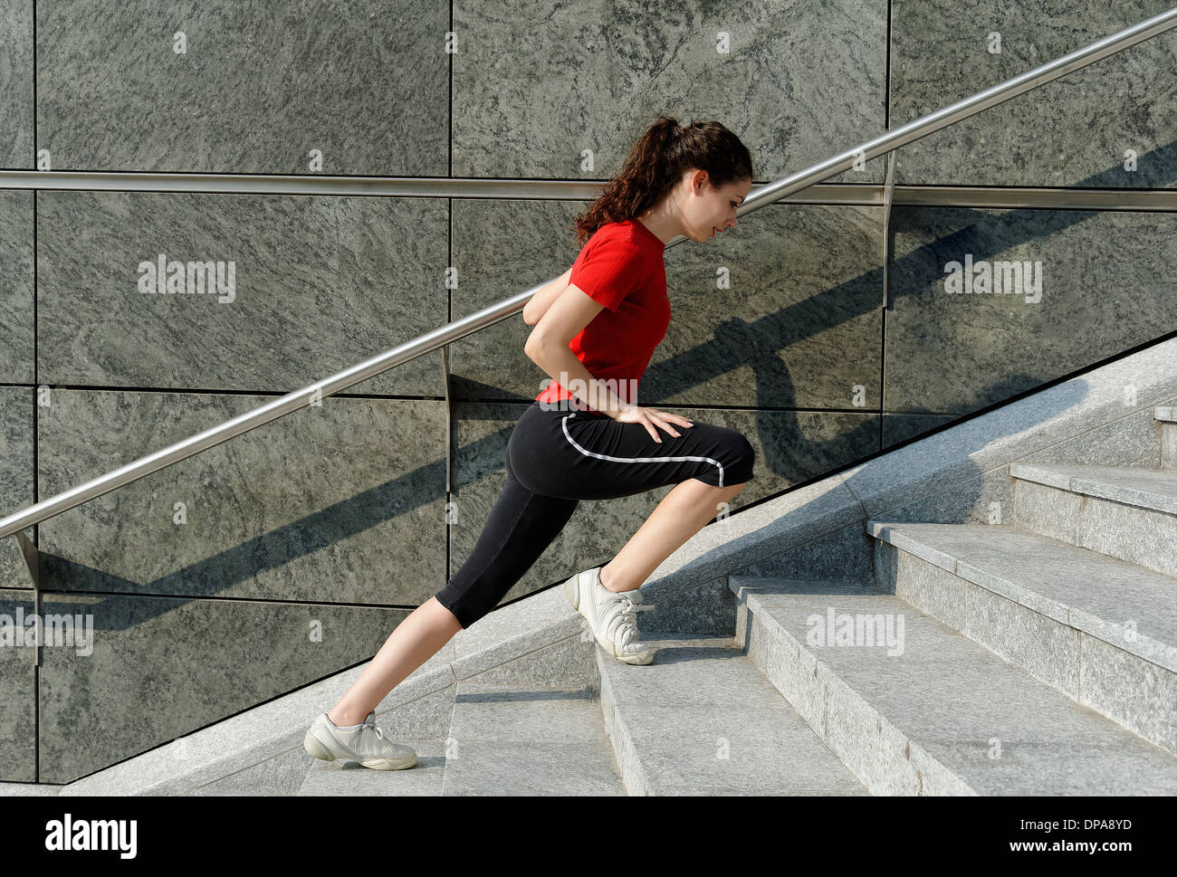 Junge Frau, die Ausbildung auf Treppe Stockfoto