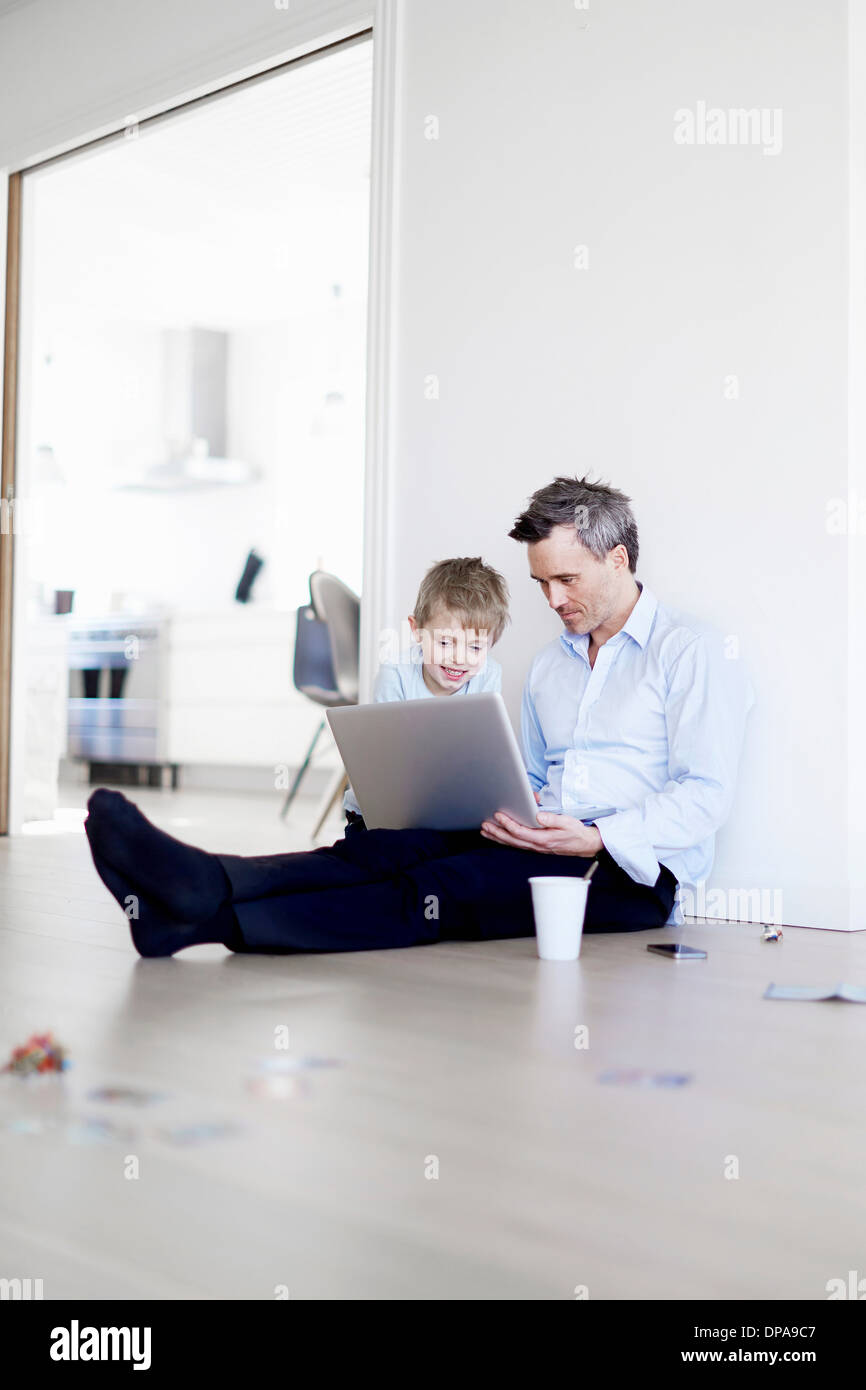 Mann mit Laptop, Sohn gerade Stock sitzt Stockfoto