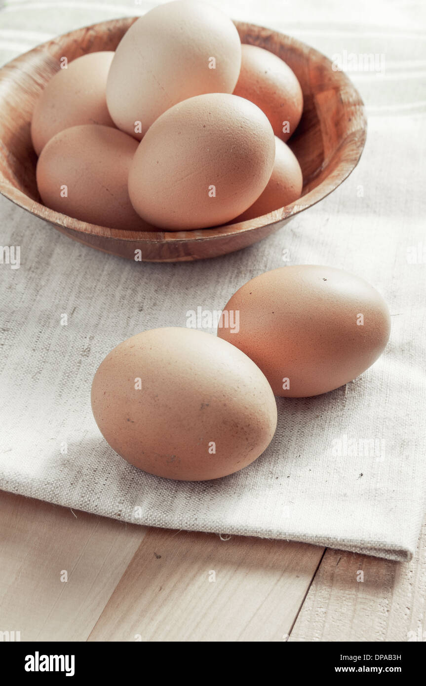 Frische Bio rohe Eiern auf hölzernen Hintergrund, Nahaufnahme Stockfoto