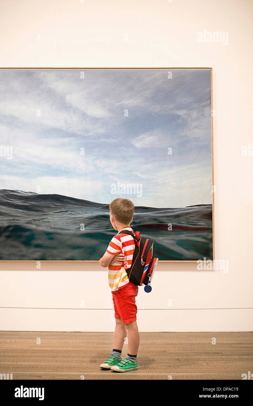 Kleiner Junge mit Blick auf Bild in Galerie Stockfoto