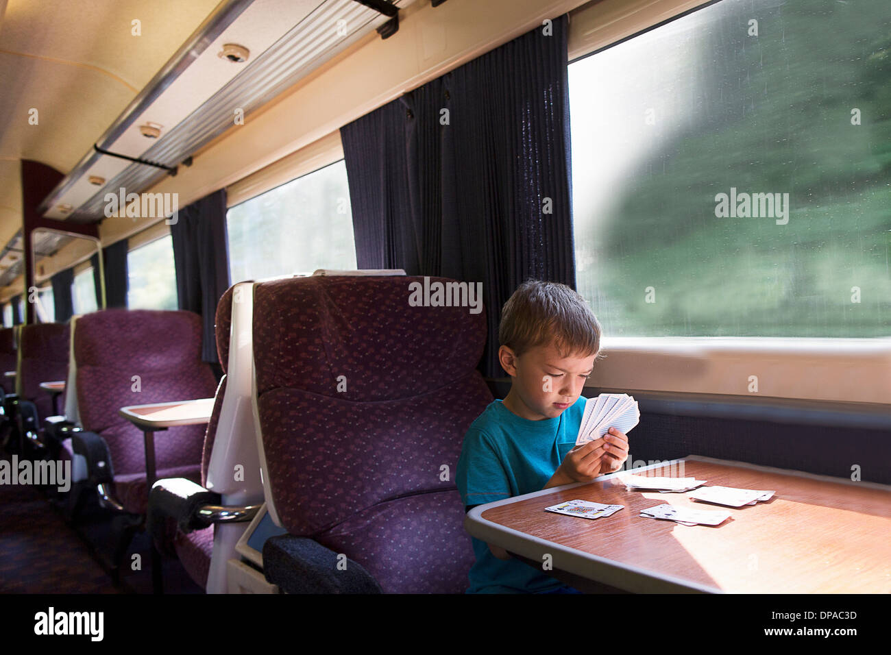 Kleiner Junge spielt Geduld auf Zug Stockfoto