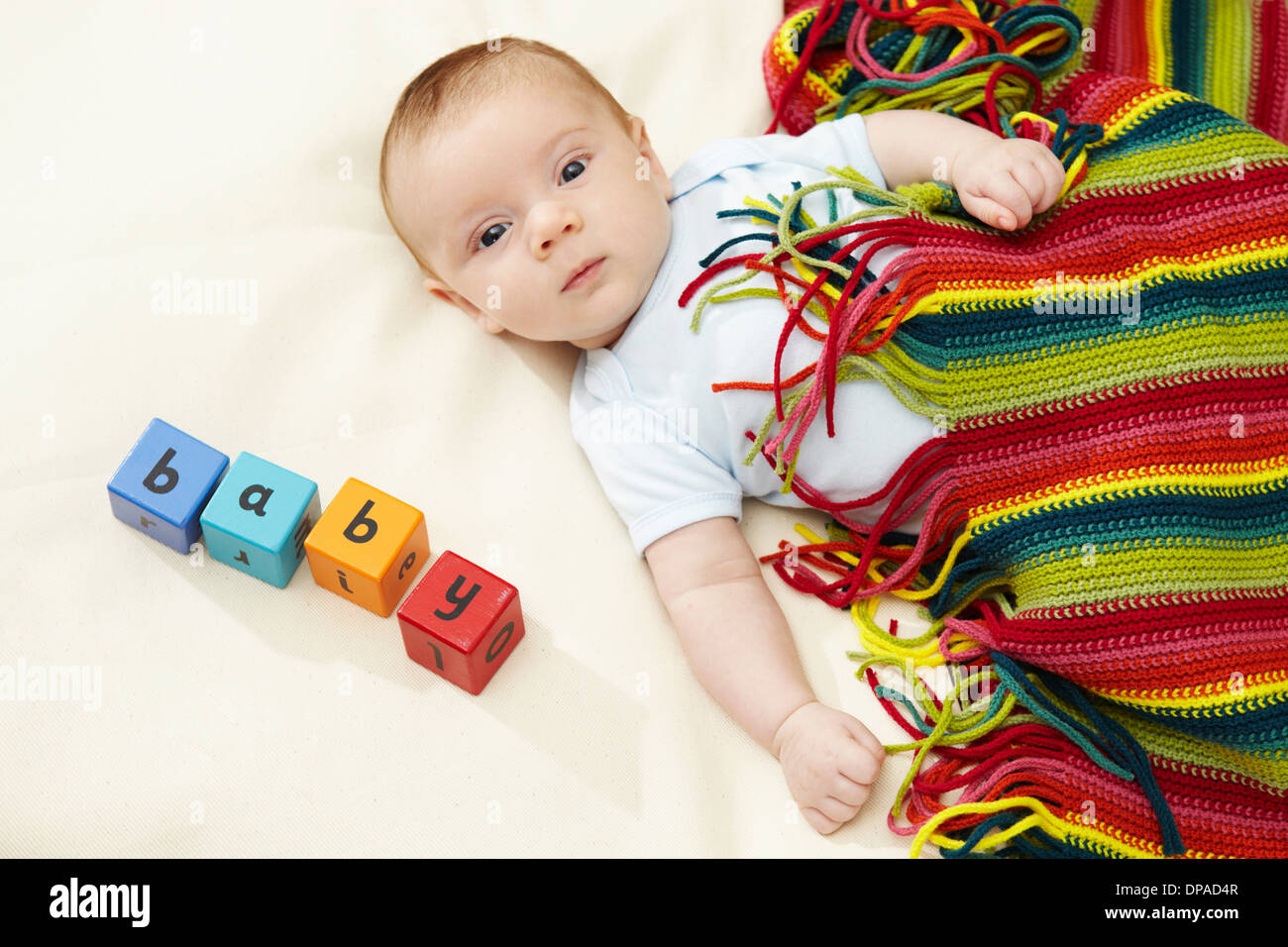 Baby Junge gestreiften Unterdecke mit Blöcken Rechtschreibung Baby liegend Stockfoto