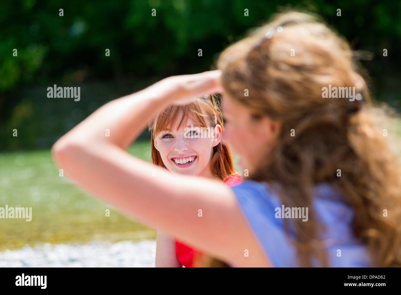Zwei Freundinnen im Sonnenlicht, eine Abschirmung Augen Stockfoto