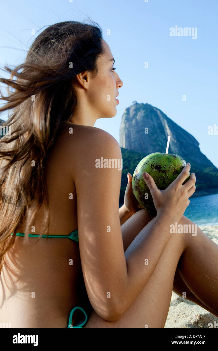 Junge Frau mit Kokosnuss Drink, Rio De Janeiro, Brasilien Stockfoto