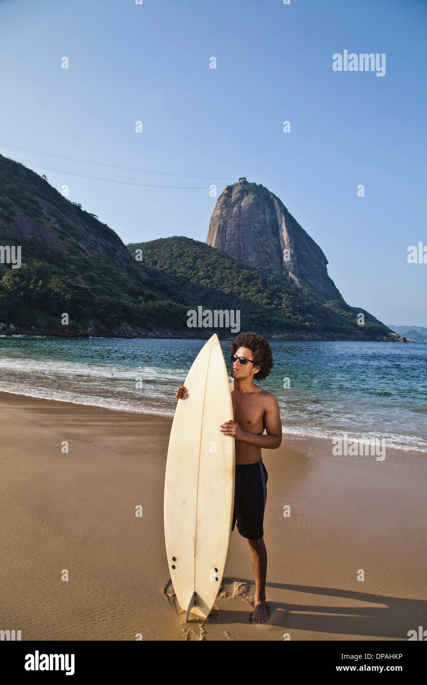 Mann mit Surfbrett am Strand von Rio De Janeiro, Brasilien Stockfoto