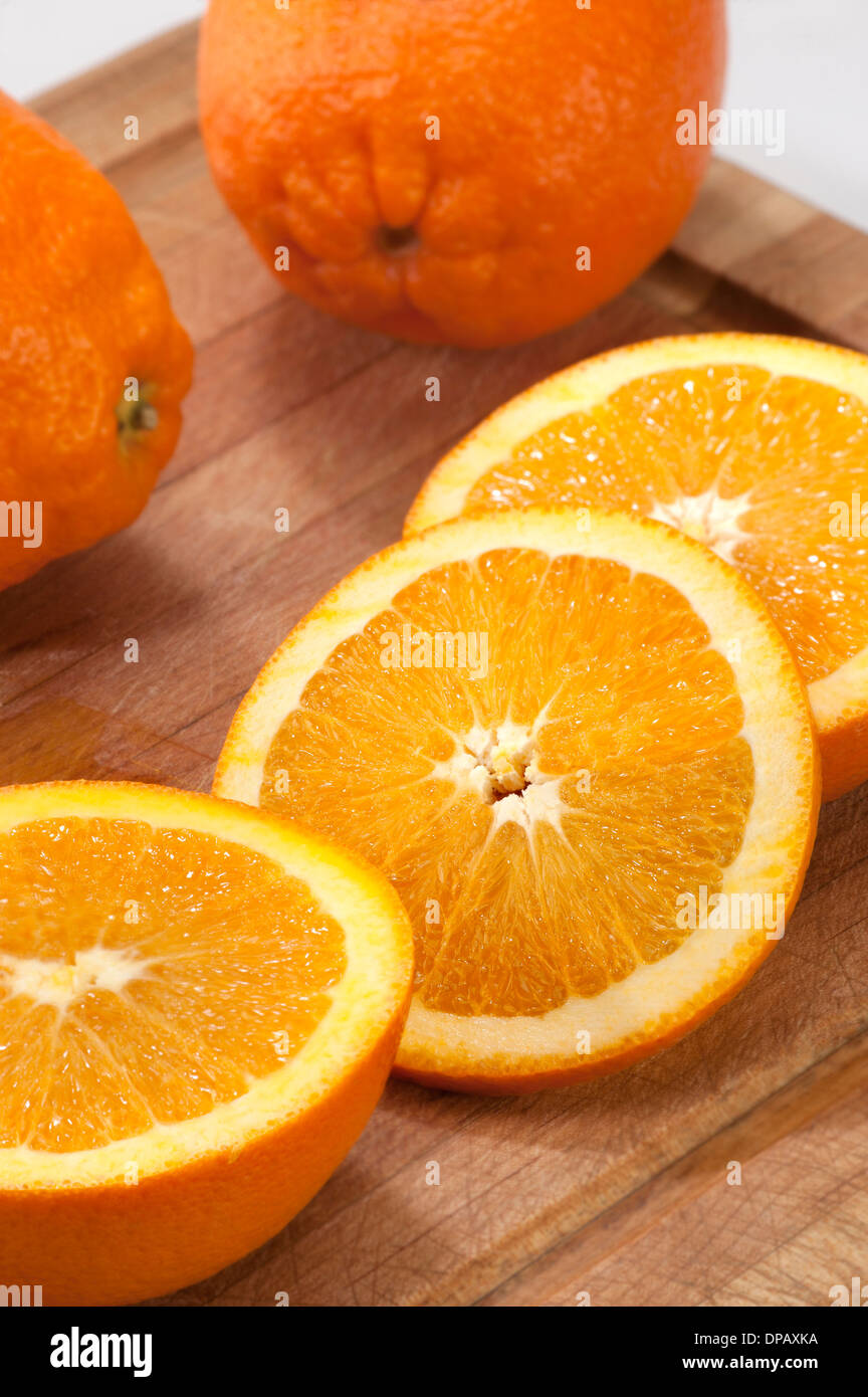 Orangen mit Scheiben auf ein Schneidebrett Stockfoto