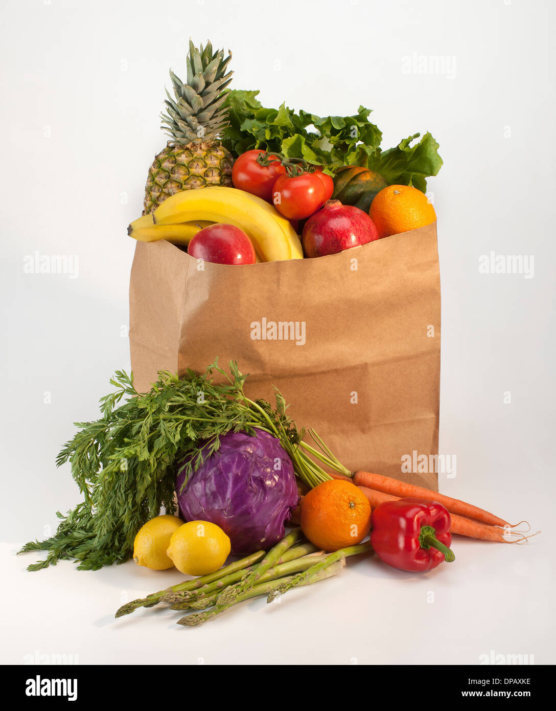 Einkaufstüte gefüllt mit Obst und Gemüse auf weißem Hintergrund mit Schatten Stockfoto