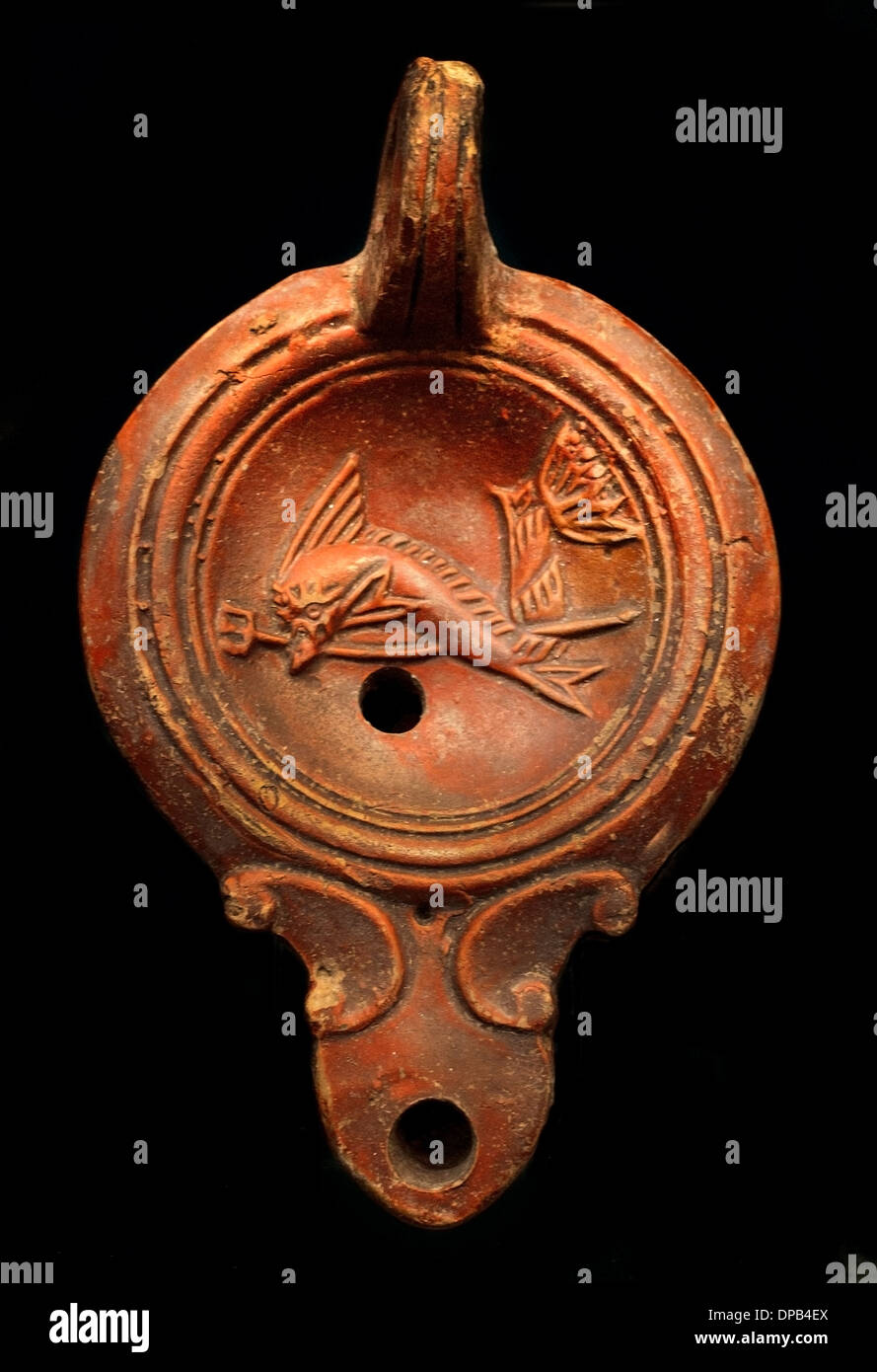 Symbole des Meeresgottes Poseidon (der Delphin ist die Boon Begleiter der Matrosen) Öl Lampe 100 n. Chr. römische Stockfoto