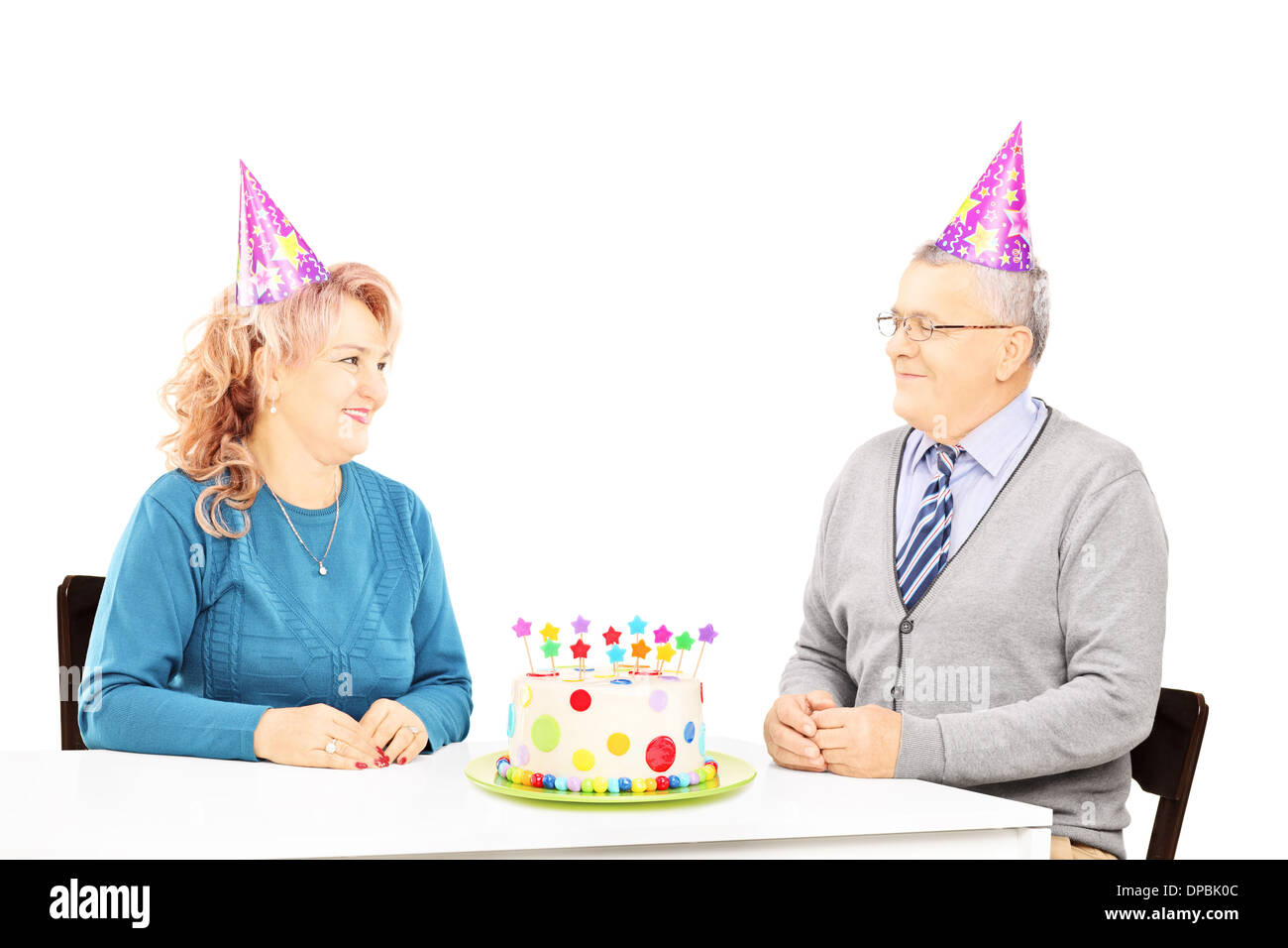 Mittleren gealterten paar auf einem Tisch mit Kuchen, sahen einander auf Geburtstagsparty Stockfoto