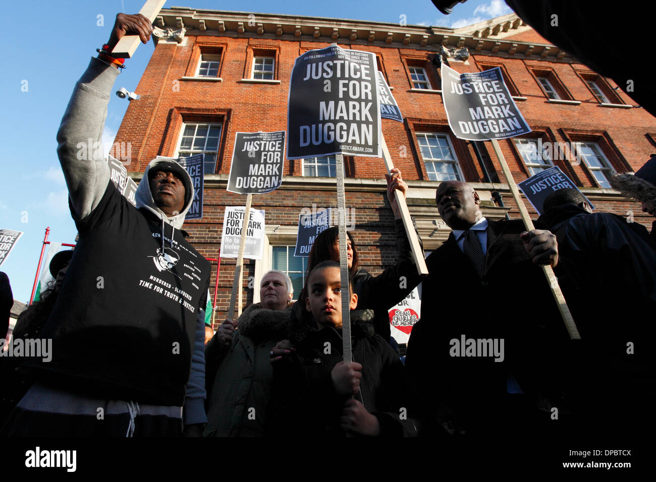 Tottenham, London, UK. 11. Januar 2014. Unterstützer stehen mit Plakaten, die lesen, "Gerechtigkeit für Mark Duggan" bei einer Mahnwache für Mark Duggan außerhalb Polizeistation statt Stockfoto