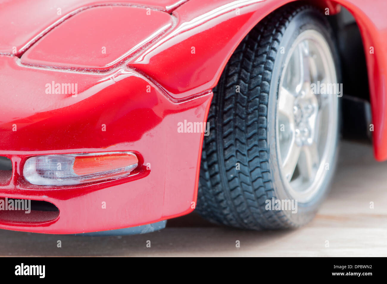 roter Sportwagen auf einem hölzernen Hintergrund Stockfoto