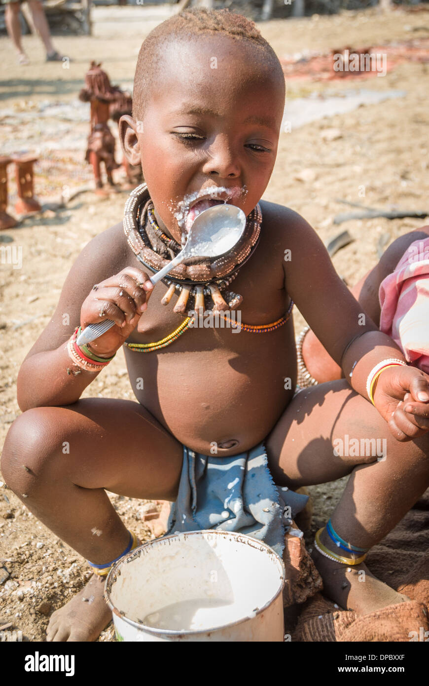 Junger Himba essen Brei aus einem Topf, Dorf in der Nähe von Epupa Wasserfälle, Kunene, Namibia, Afrika Stockfoto