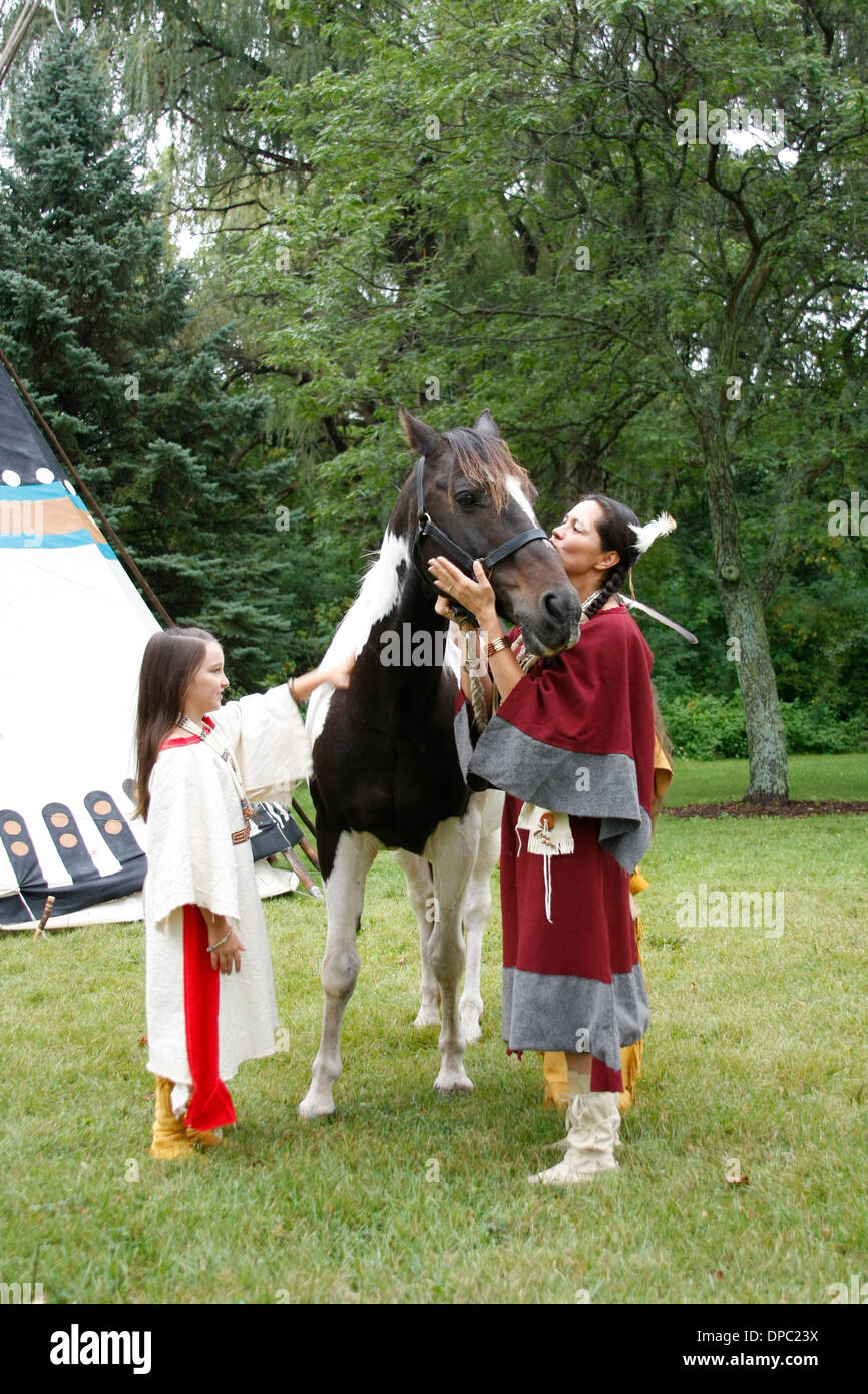 Eine Native American Indian-Familie mit ihren Farben-Pferd neben einem tipi Stockfoto