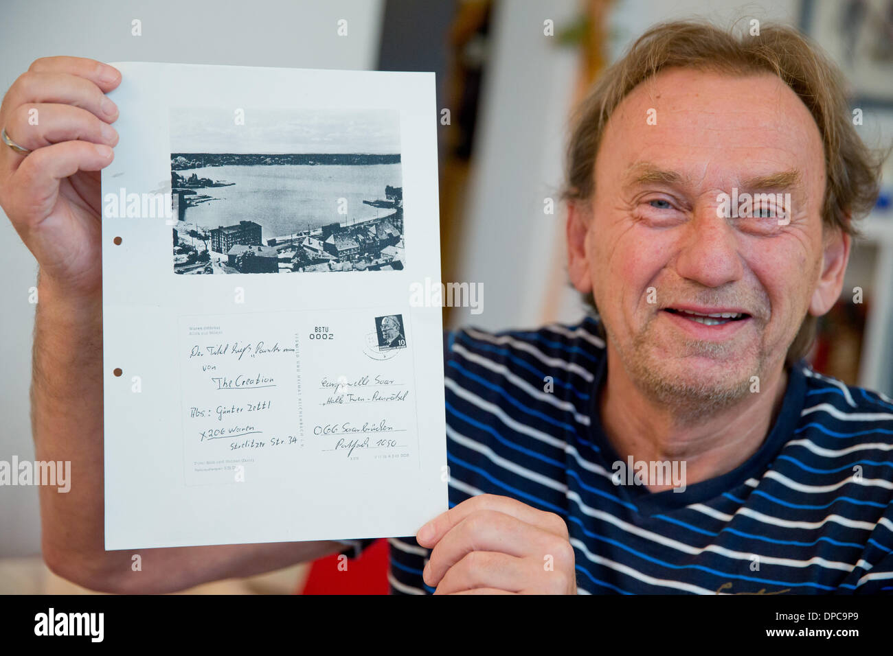 Erlangen, Deutschland. 9. Januar 2014. Guenter Zettl hält seine Stasi-Akten, auf dem die Kopie eine Postkarte von ihm im Jahre 1969 in Erlangen, Deutschland, 9. Januar 2014 abzuwarten, kann ein Blatt Papier. Als ein High School hatten Schüler waren eine der Müritz in der DDR (jetzt Mecklenburg-Vorpommern) Zettl 1969 in einem Preis-Puzzle von Saarland Radio (SR) teilgenommen. Er schickte diese Postkarte, die nun nach 44 Jahren angekommen. Foto: DANIEL KARMANN/Dpa/Alamy Live News Stockfoto