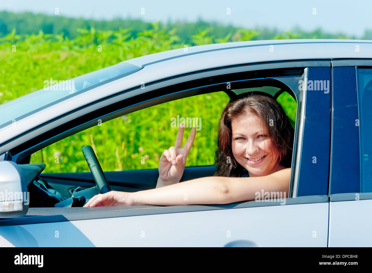 lächelndes Mädchen Autofahren auf Natur Stockfoto