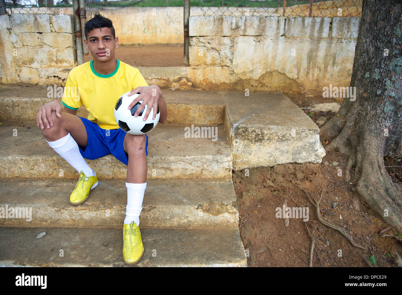 Porträt der jungen brasilianischen Fußballspieler, Fußball sitzen im Freien in seiner Nachbarschaft favela Stockfoto