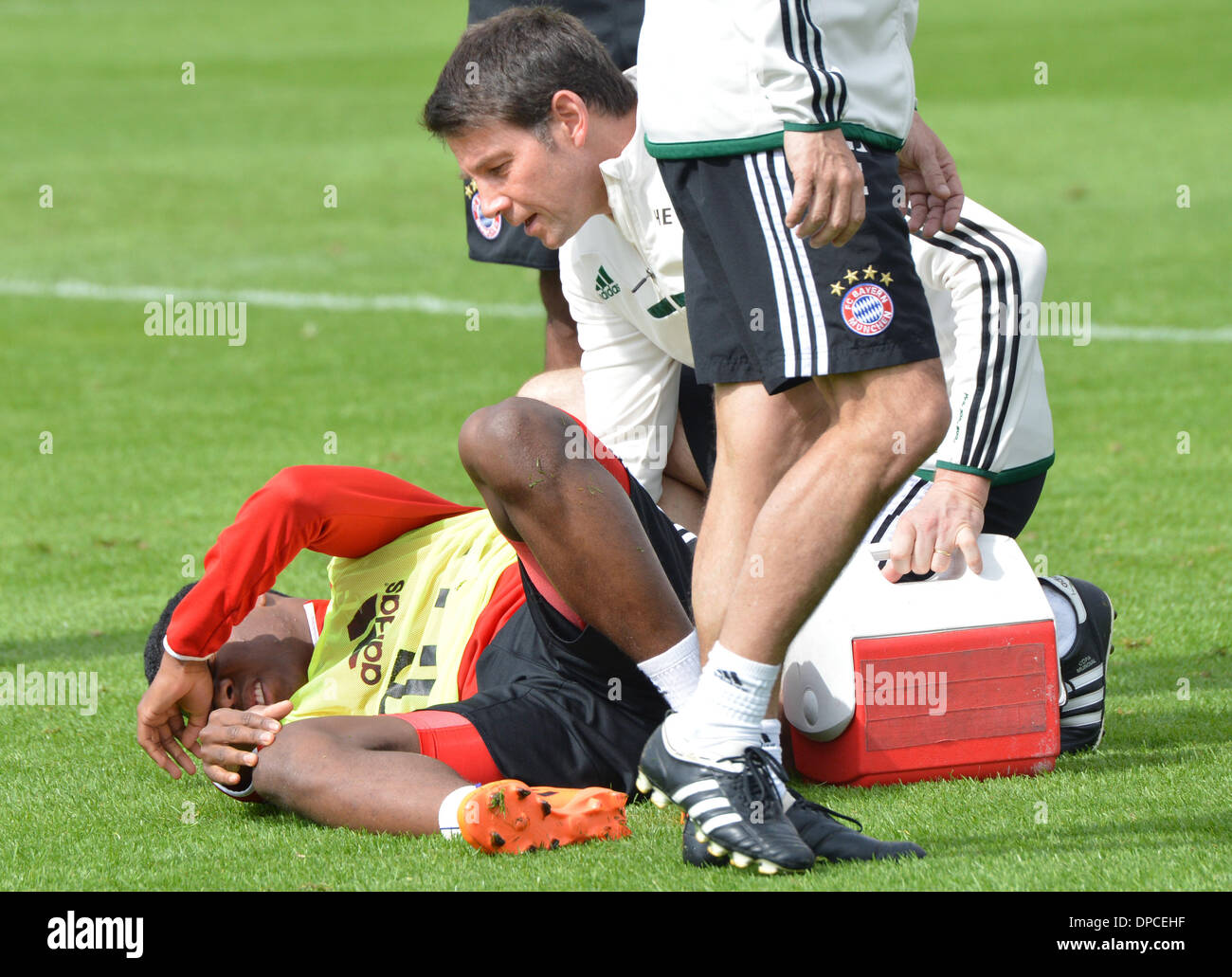 Doha, Katar. 12. Januar 2014. FC Bayern München David Alaba liegt auf dem Spielfeld mit einem verletzten Knie Investitur pro Trainingseinheit in Doha, Katar, 12. Januar 2014. Bayern München bleibt in Katar bis 13. Januar 2014, für die zweite Hälfte der deutschen Fußball-Bundesliga-Saison vorzubereiten. Foto: Peter Kneffel/Dpa/Alamy Live News Stockfoto