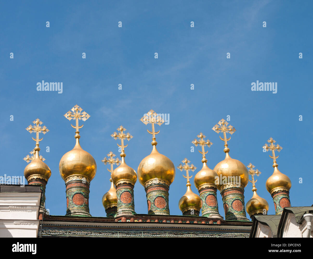 Der Kreml, Moskau, Detail, zahlreiche kleine vergoldete Zwiebel Kuppeln mit farbigen Base und Kreuze gegen blauen Himmel Stockfoto