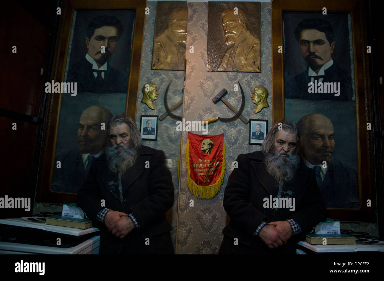 Eine alte Mitglied der ehemaligen kommunistischen Partei in Yerevan Armenien vor die Porträts der Führer der kommunistischen Partei Stockfoto