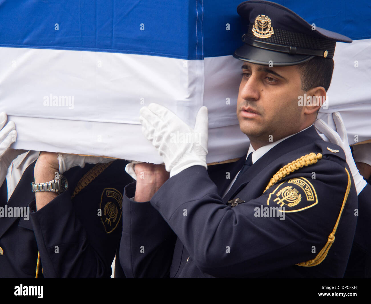 Der Sarg des ehemaligen Ministerpräsidenten Ariel Sharon, kommt in der Knesset, eingehüllt in die israelische Flagge. Jerusalem, Israel. 12. Januar 2014.  Der Sarg des ehemaligen Ministerpräsidenten Ariel Sharon, kommt in der Knesset für eine Kranzniederlegung Zeremonie und die Öffentlichkeit auf die letzte Ehre erweisen zu ermöglichen. Sharon vergangen Samstag im Alter von 85 nach einer achtjährigen Schlaganfall-Koma. Stockfoto