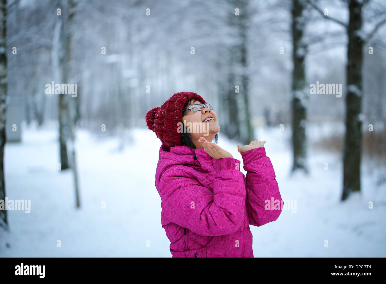 Jung und glücklich Asiatin mit einer rosa Jacke genießt schneit Stockfoto
