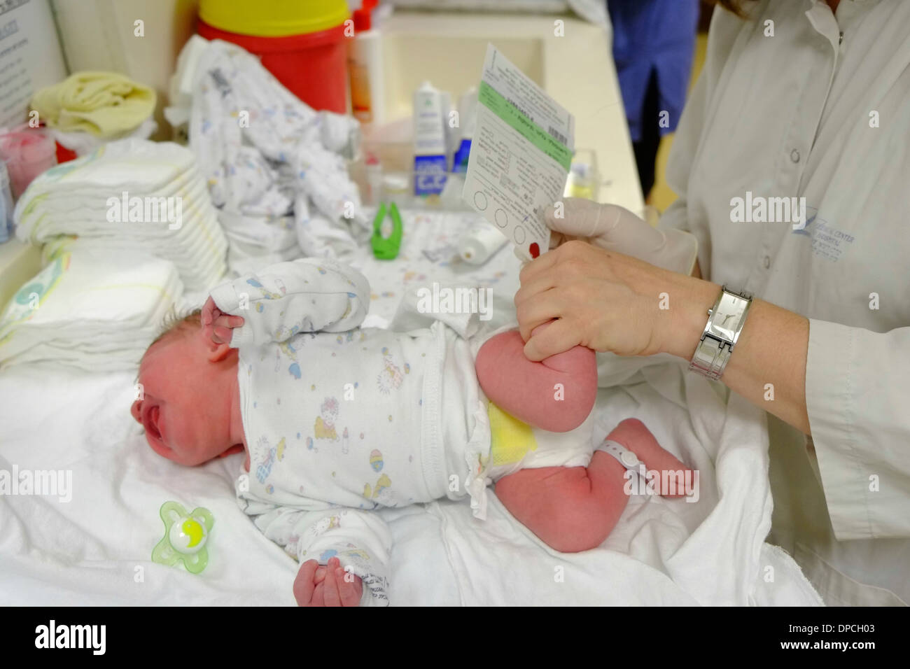 Arzt führt eine Blutuntersuchung auf ein neugeborenes Kind in einer Entbindungsstation Stockfoto