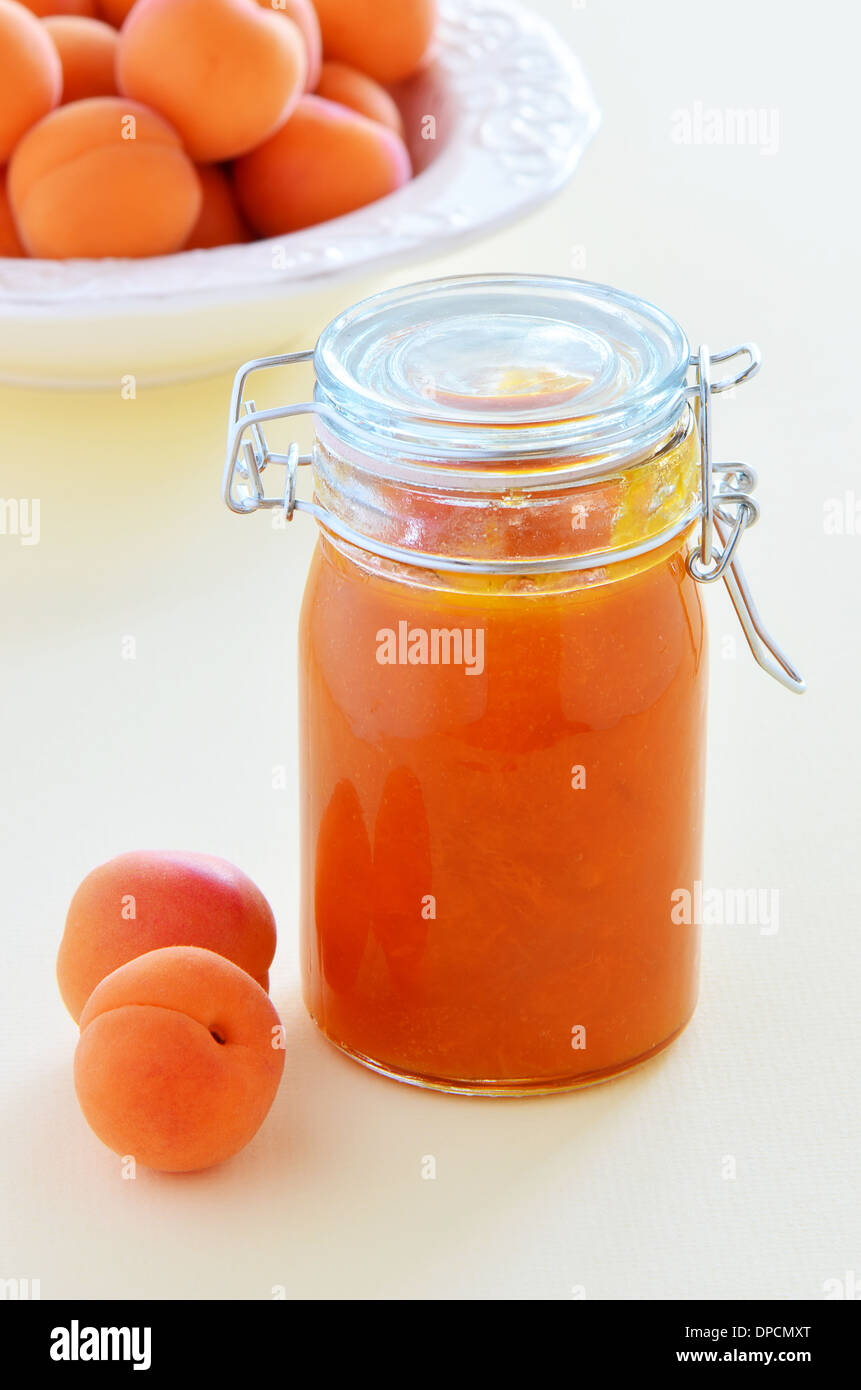 Frischen Reifen Aprikosen und hausgemachte Marillenmarmelade in einem Glas im Hochformat Stockfoto