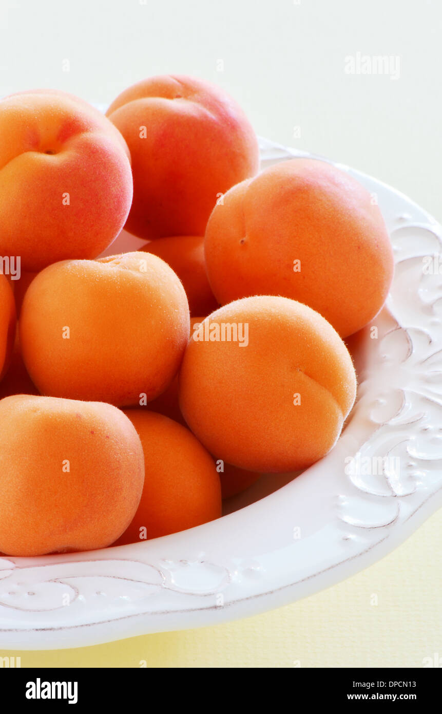 Frische reife Aprikosen in eine hübsche Schale in Hochformat Stockfoto