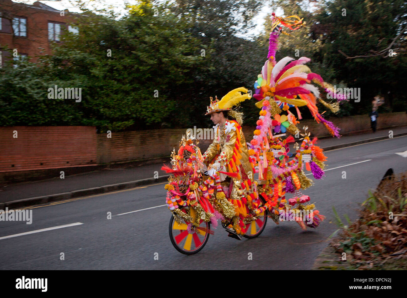 Radfahrer und Fahrrad im Karnevalsstil in mehrfarbigen Dekorationen auf der Wimbledon Hill Road Stockfoto