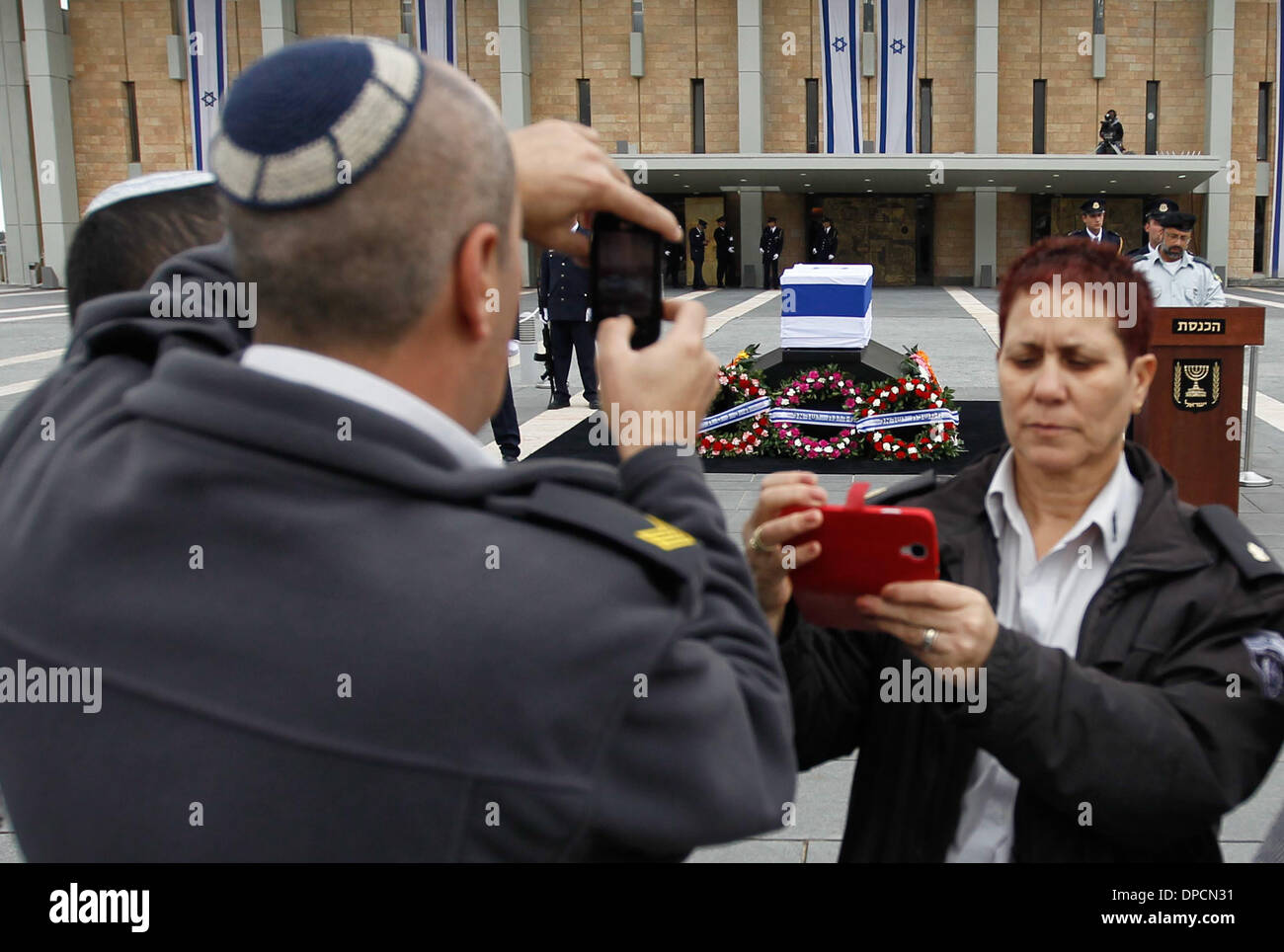 Jerusalem. 12. Januar 2014. Israelis fotografieren, wenn Sie ihren Respekt zu ehemaligen israelischen Ministerpräsidenten Ariel Sharon am Eingang Platz der israelischen Knesset (Parlament) in Jerusalem, am 12. Januar 2014 zu bezahlen. Ehemaligen israelischen Ministerpräsidenten Ariel Sharon, eine umstrittene Abbildung, die den Kurs des Nahen Ostens verändert starb in einem Krankenhaus in der Nähe von Tel Aviv in Zentral-Israel am Samstag im Alter von 85. Bildnachweis: JINI/Xinhua/Alamy Live-Nachrichten Stockfoto