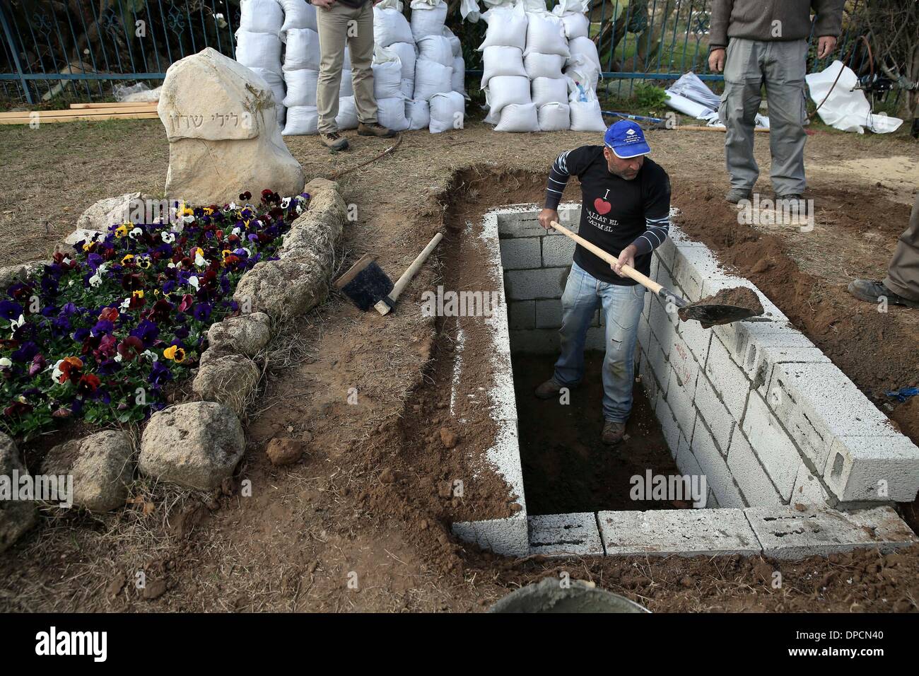 Sderot, Israel, 12. Januar 2014.  Arbeiter bereiten das Grab für Ariel Sharon in Südisrael Havat Hashikmim, außen Sderot, am 12. Januar 2014. Der ehemalige israelische Ministerpräsident Ariel Scharon starb am Samstag im Alter von 85, der Direktor der Rehabilitationsklinik an der Sheba Medical Center, die Shlomo Noy auf einer Pressekonferenz im Krankenhaus bestätigt. (Xinhua) Stockfoto