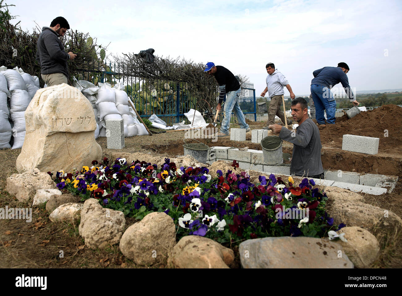Sderot, Israel, 12. Januar 2014.  Arbeiter bereiten das Grab für Ariel Sharon in Südisrael Havat Hashikmim, außen Sderot, am 12. Januar 2014. Der ehemalige israelische Ministerpräsident Ariel Scharon starb am Samstag im Alter von 85, der Direktor der Rehabilitationsklinik an der Sheba Medical Center, die Shlomo Noy auf einer Pressekonferenz im Krankenhaus bestätigt. (Xinhua) Stockfoto