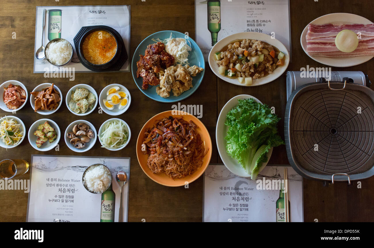 Koreanisches Restaurant Essen - gegrillter Schweinebauch, Brathähnchen, Tiefe gebratenes Schweinefleisch, Schnecke Salat, Tofu Suppe und Banchan (Beilagen) Stockfoto