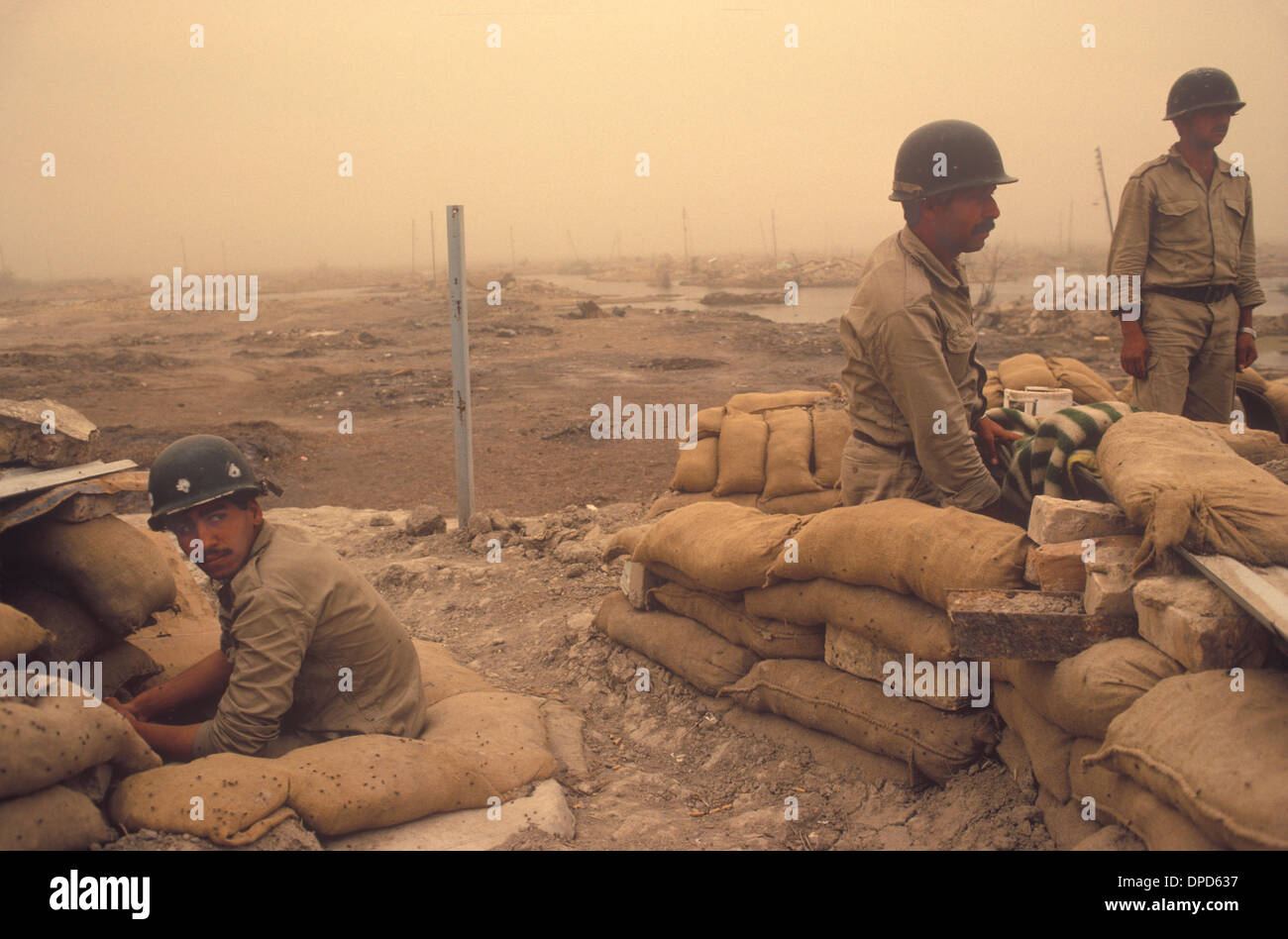 Iranirakkrieg, auch bekannt als erster persischer Golfkrieg oder Golfkrieg. 1984 Soldat, der sich von der jüngsten Schlacht erholt hat, nimmt noch immer ihre Position unter den Verwüstungen des Krieges in den Mesopotamianischen Sümpfen ein. Ein Sandsturm in der Luft. Nahe Basra Südirak. 1980er HOMER SYKES Stockfoto