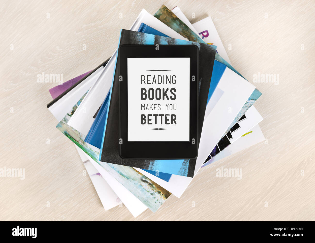 Bücher lesen macht Sie besser - Text auf einem Bildschirm des elektronischen Buches liegt oben auf einem Stapel von Büchern und Zeitschriften Stockfoto