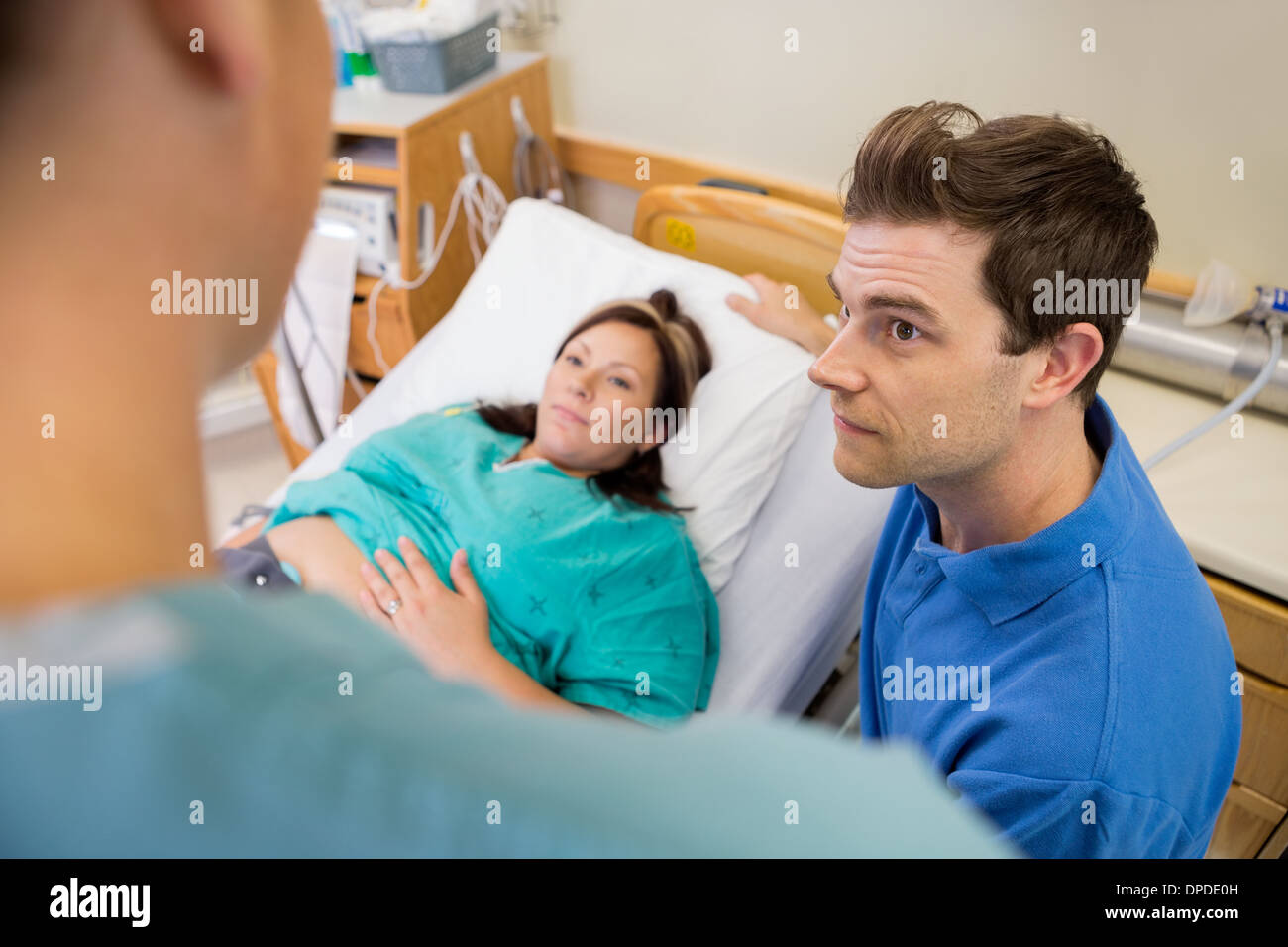 Mann und schwangere Frau anhören Krankenschwester im Krankenhaus Stockfoto