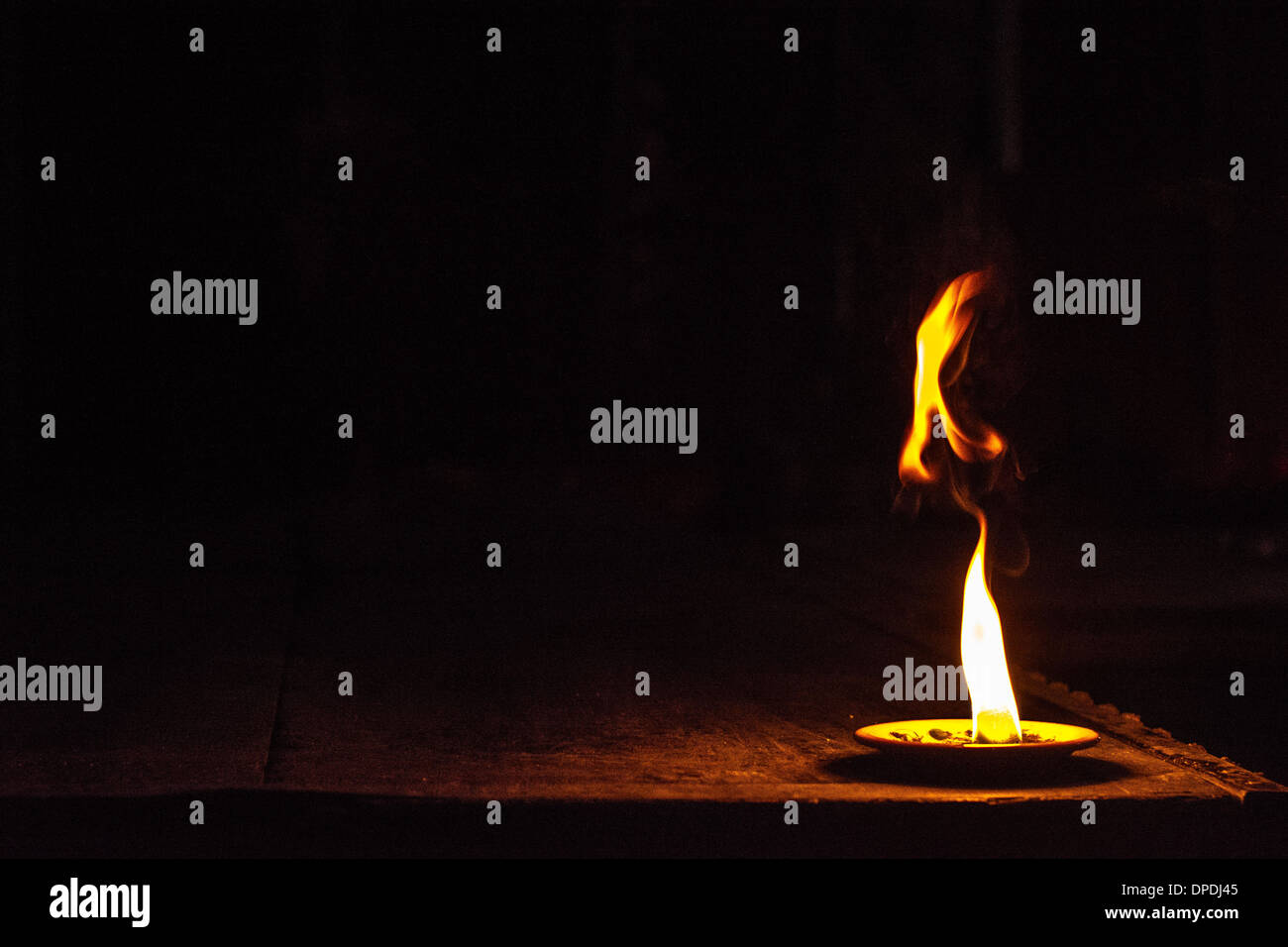 Brennende Flamme auf einem dunklen Bühnenbild Stockfoto