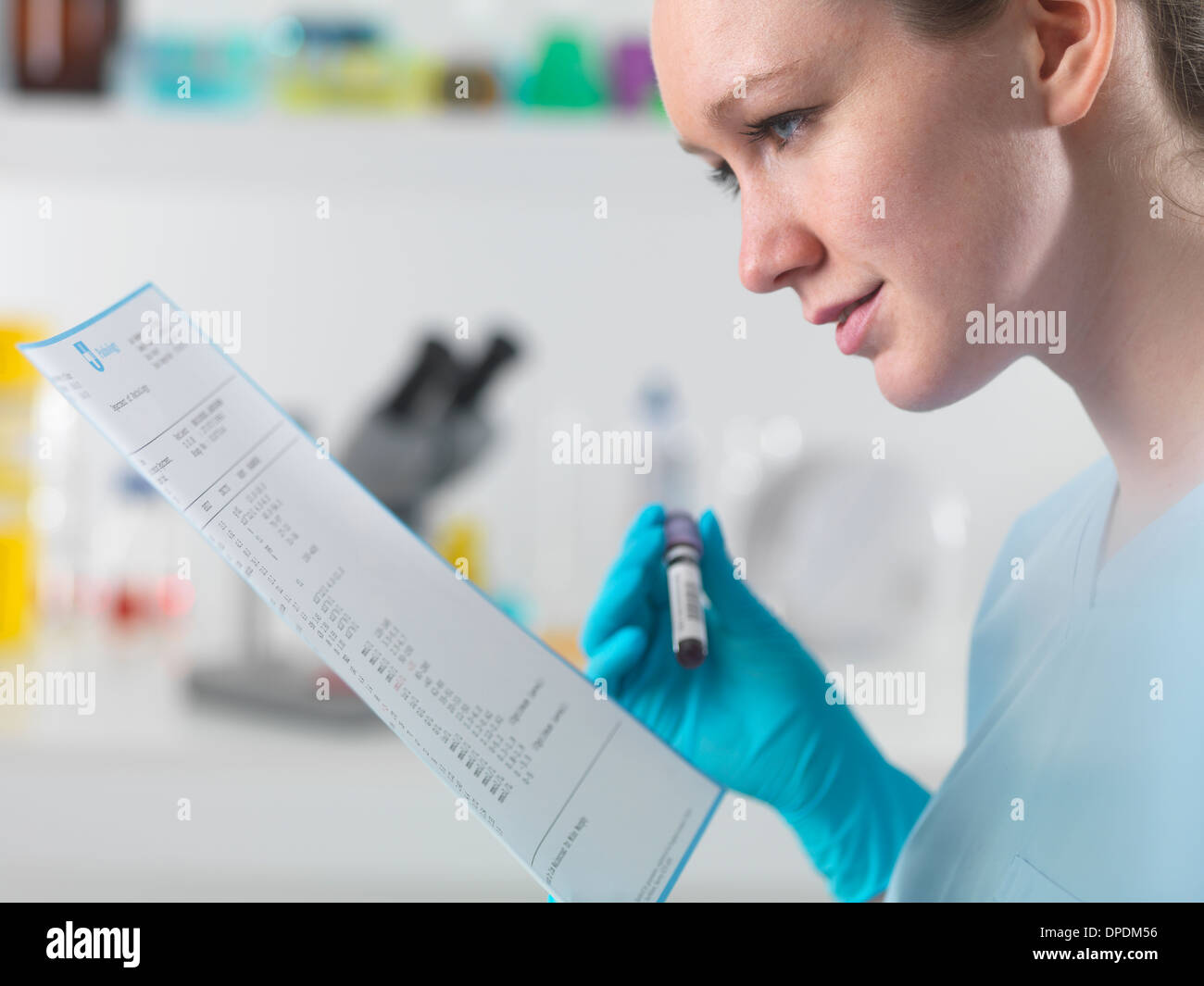 Techniker halten Blutprobe im klinischen Labor mit Testergebnissen Stockfoto