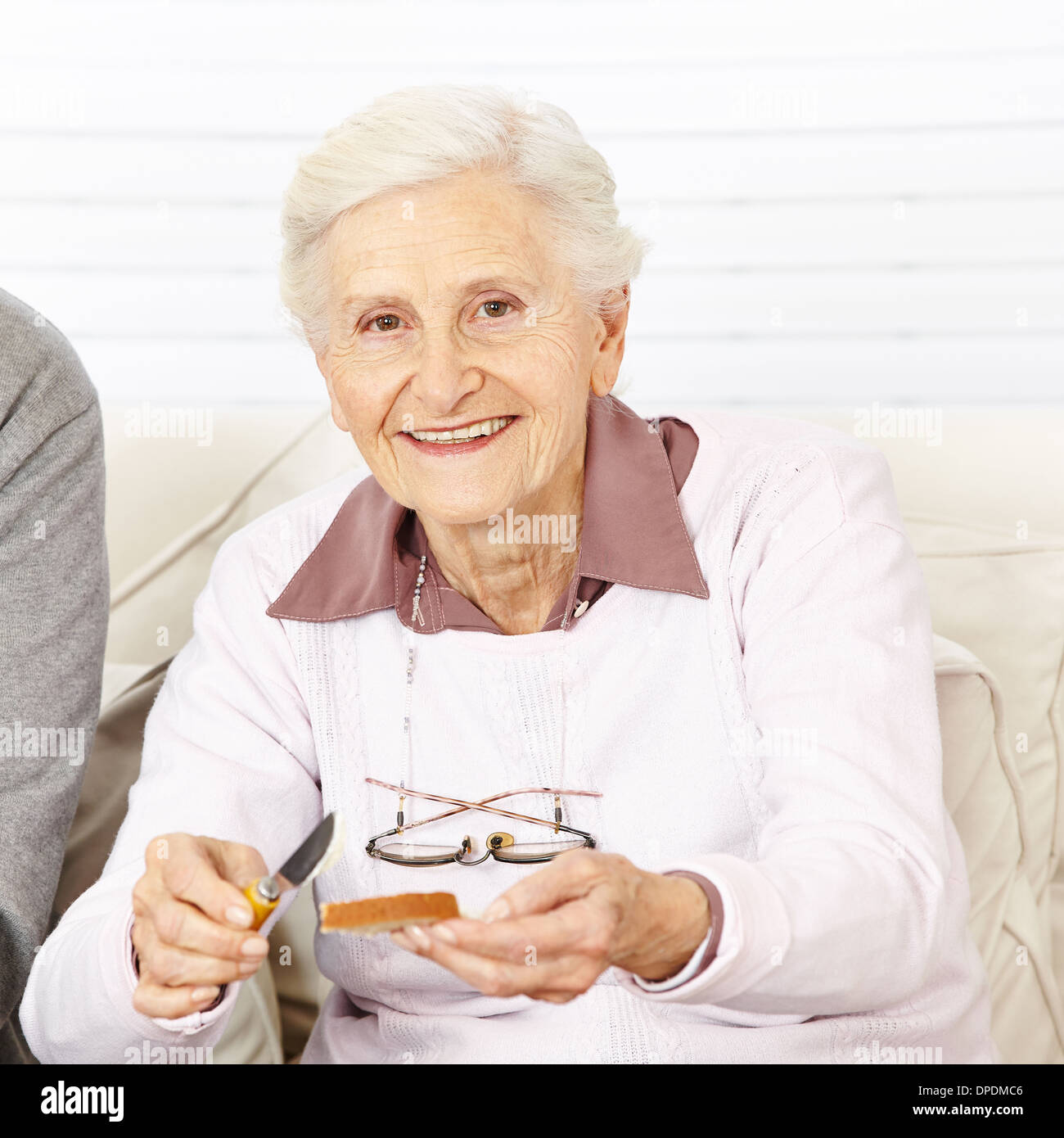 Alten senior Frau Pam einen Toast zum Frühstück zu Hause Stockfoto